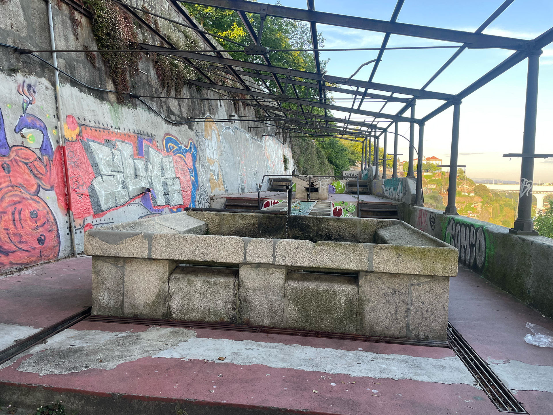 Outdoor washhouse visited during research, featuring stone basins and a graffiti-covered wall.